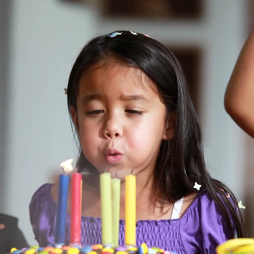 Happy Birthday: Ein Geburtstag ist ein guter Anlass, um Spenden zu sammeln Geburtstage als Spendenanlass: ein Mädchen pustet die Kerzen auf ihrem Geburtstagskuchen aus