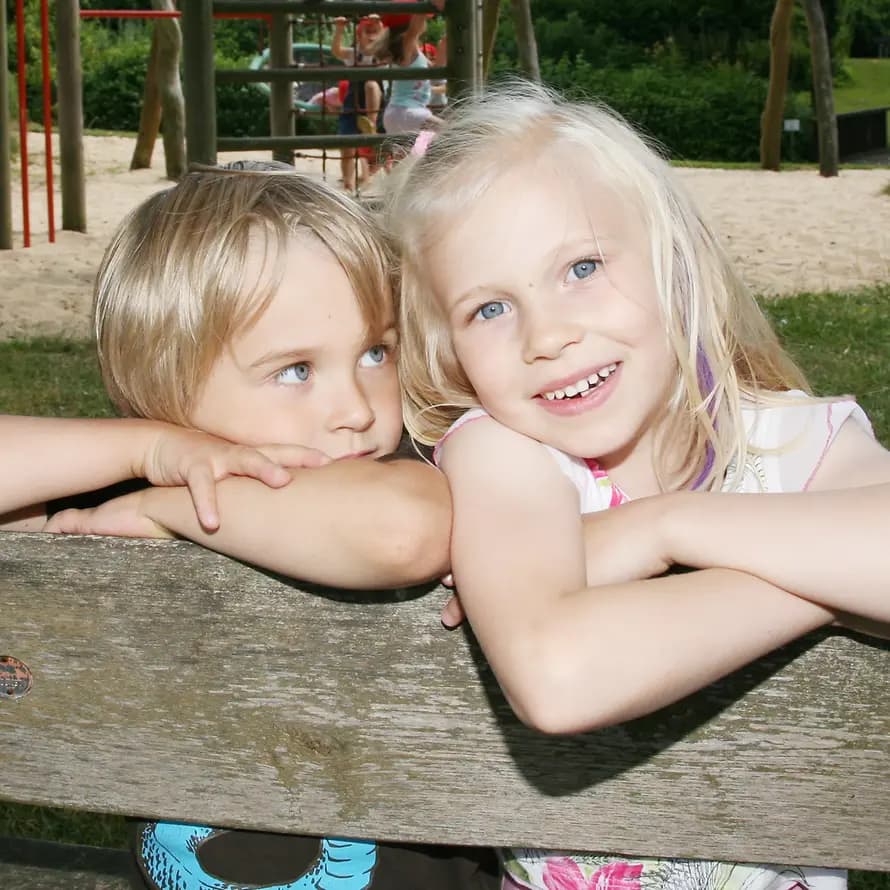 Zwei Kinder aus dem SOS-Kinderdorf genießen den Sommer auf einer Bank
