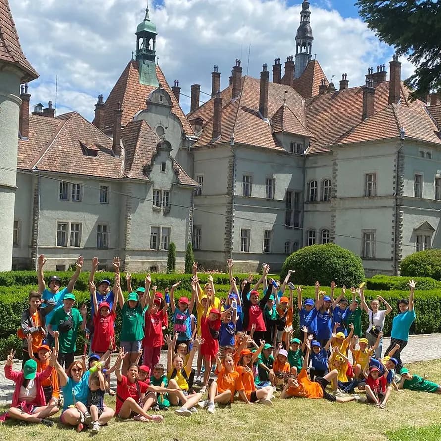 74798_SOS-KD_Ukraine_Sommercamp_2022_05.jpeg Eine Gruppe Kinder posiert vor einem Schloss in der Ukraine