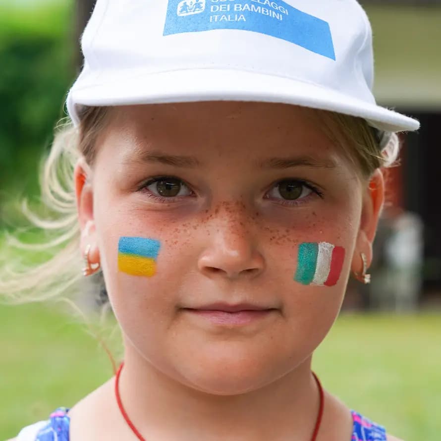74972_SOS-KD_Caldonazzo_Ukrainische-Familien_Juli2022_50.jpg Mädchen mit aufgemalter Ukraine- und Italienflagge im Gesicht