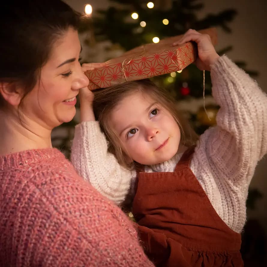 Geschenkewahn zu Weihnachten Mädchen mit Mutter und Geschenk