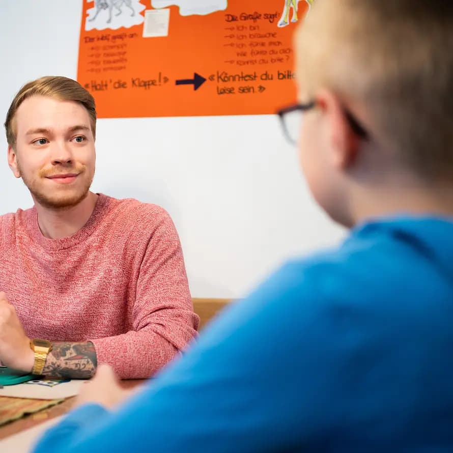 56981_SOS-KD-Kaiserslautern_Reportage-Tagesgruppe_11052021_AndreasHenn-7591.jpg Betreuer der Tagesgruppe Kaiserslautern am Tisch im Gespräch mit einem Jungen