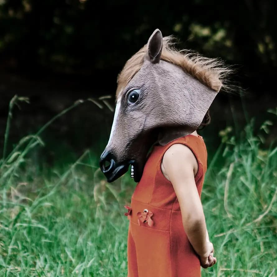 Mehr Therapieplätze für Kinder: Jetzt Petition unterscheiben! Kind auf Wiese mit Pferdekopfmaske