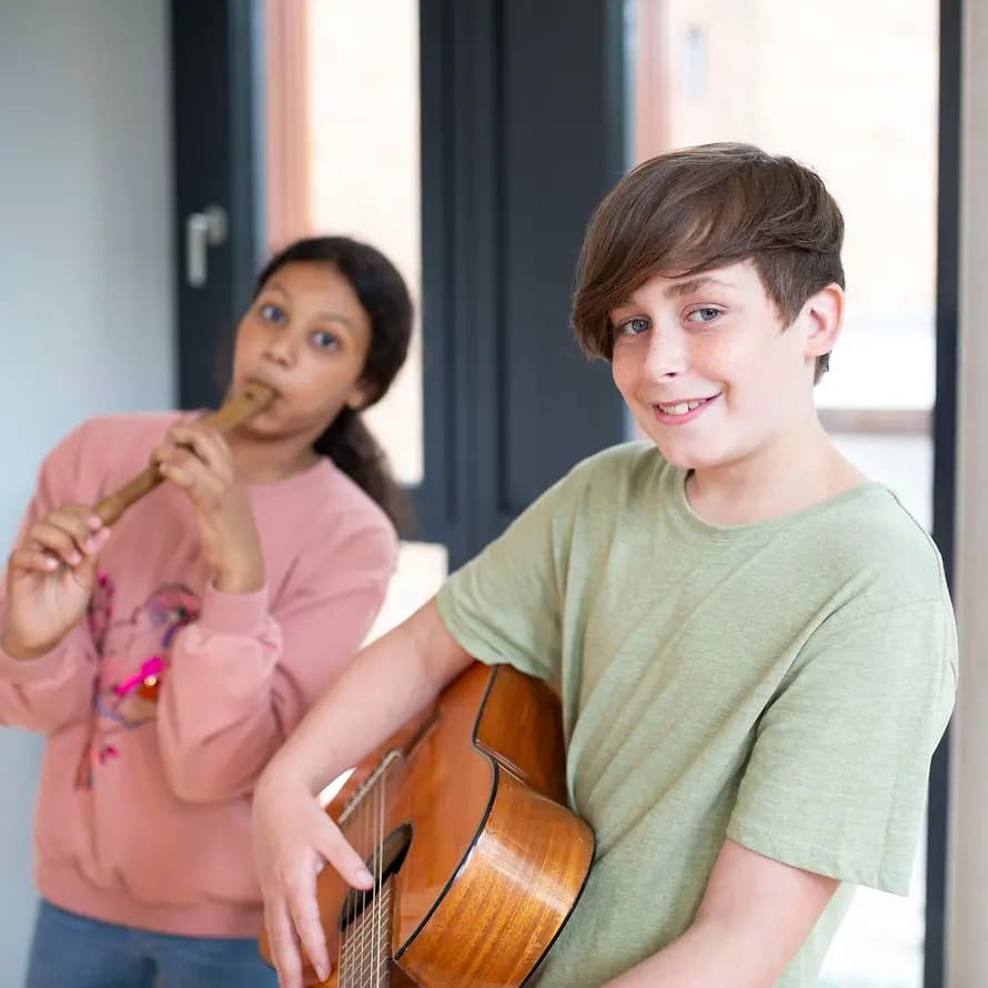 Musikinstrument Ein Junge und ein Mädchen spielen ein Musikinstrument