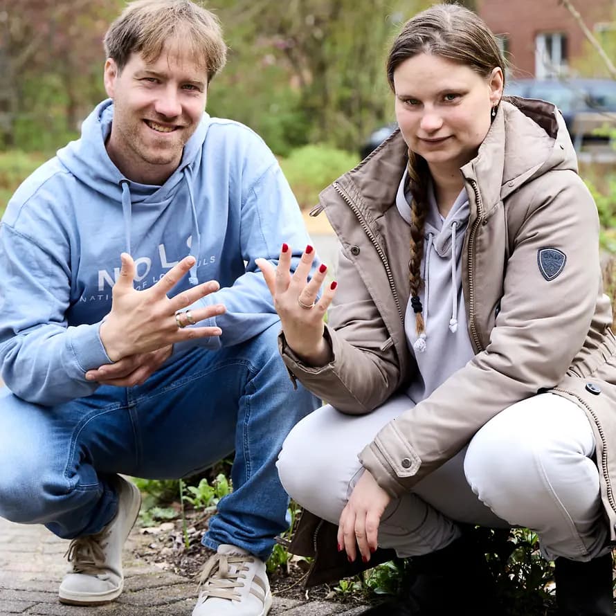 99815_SOS-Hof_Bockum_Magazin0225_Schmidt_Bildplantage13_240425_ 38.jpg Annabell und Marcel in der Hocke zeigen ihre Ringe an den Fingern