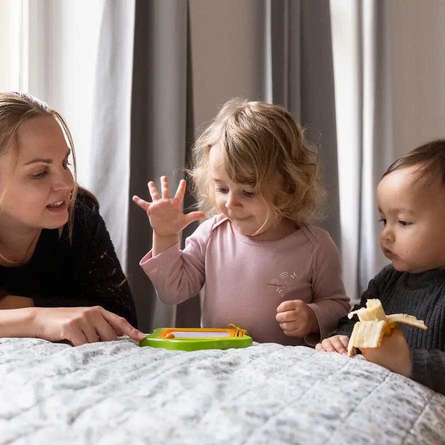 123142_SOS-KD_Berlin_HTS_Mini_Kinderdorffamilie_SebastianPfuetze_20251028_1476.jpg Kinderdorfmutter Lea spielt mit Ida und Mika ein Spiel.