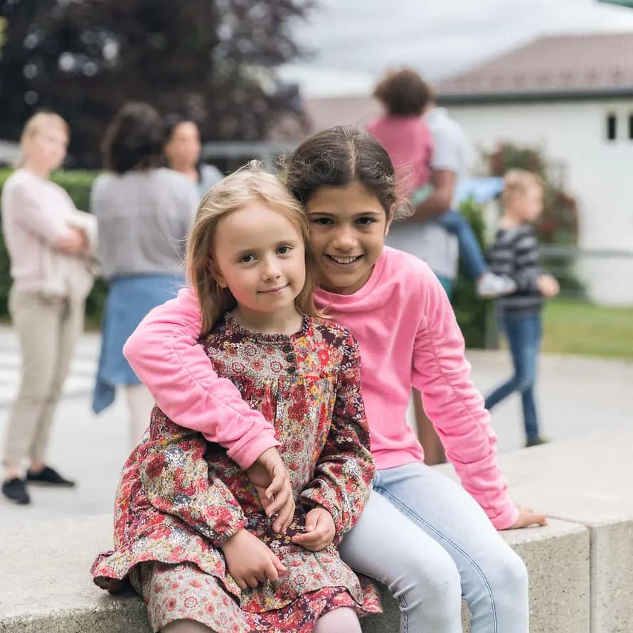 Ersetzt durch MDB 44246 April 2021 Kinder auf einer Bank - im Hintergrund reges Treiben im SOS-Kinderdorf