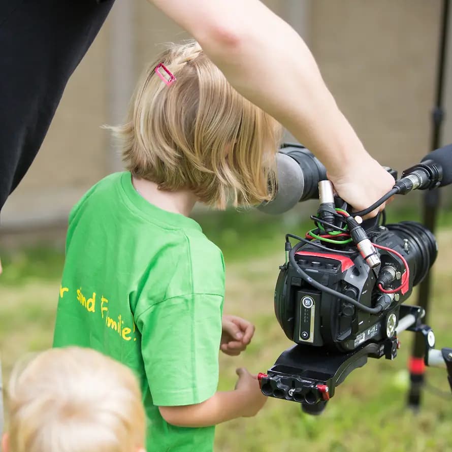 Bewegtbild von SOS-Kinderdorf Mann zeigt kleinem Mädchen eine Filmkamera
