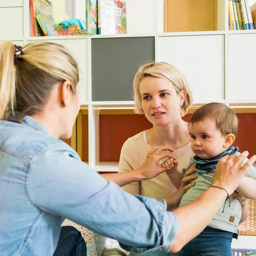 Beratung bei SOS-Kinderdorf Beratungssituation zwischen zwei Frauen mit einem Baby